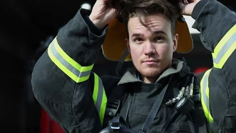 Fireman puts on red fire helmet with face protective glass Stock Footage 276368472