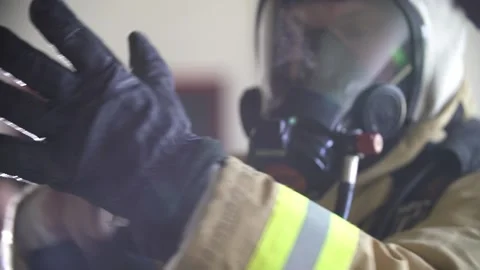 Fireman putting on his gloves with light shining in background Stock Footage 146278247