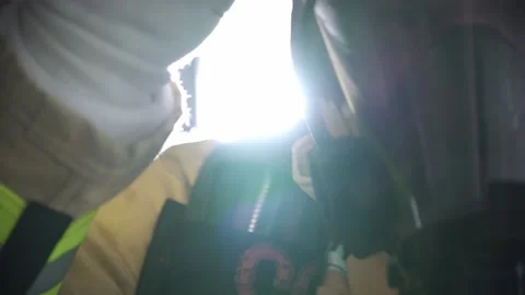 Fireman putting on his helment with light shining in background Stock Footage 146278239
