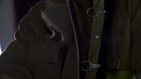 Fireman putting on his jacket with light shining in background Stock Footage 146278261