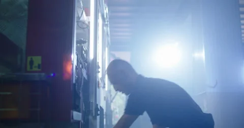 Fireman putting hoses into fire engine Stock Footage 138521049