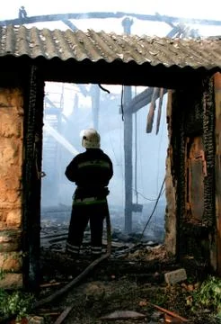 Fireman putting out a house fire Stock Photos