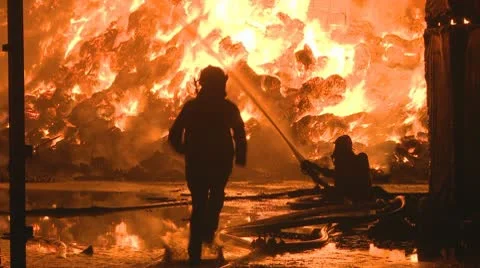Fireman runs to assist at a large fire Stock Footage 10686112