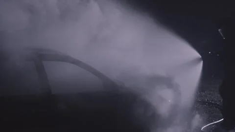 Fireman silhouette combating flames of a burning car accident at night in slow Stock-Footage 278516517