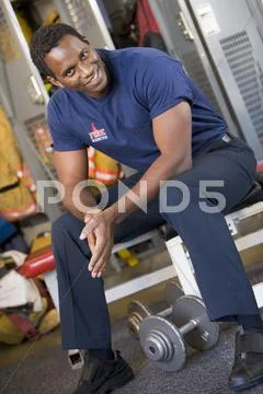 Fireman sitting on bench in fire station locker room Stock Image #21537086