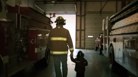 Fireman With Son In Fire Station Stock Footage