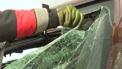 A FIREMAN TAKES PART OF A CRYSTAL CAR WITH HIS HAND Stock Footage 166732130