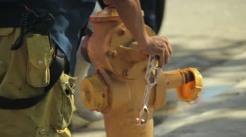 Fireman turning on a fire hydrant Stock Footage 12554688