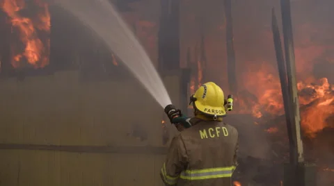 Fireman using a high pressure hose on a structure fire Vidéo 59515548