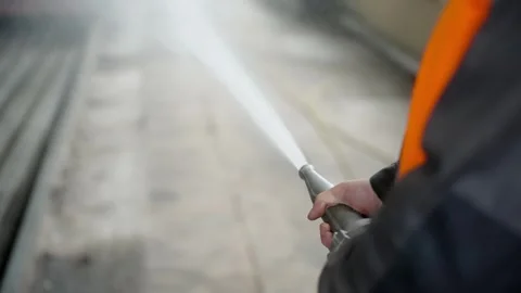 Fireman using a high pressure hose for fire fighting, pouring water Stock Footage 274490450