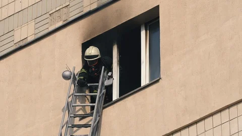 Fireman in the window of a burning apartment. Fire in the building Stock Footage 119601955