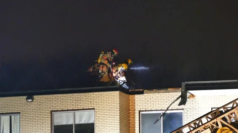 Fireman working with chainsaw on the roof of a active fire Video stock 114741765