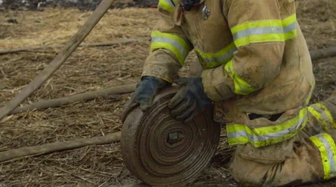 Fireman wraps up fire hose Stock Footage 61181356