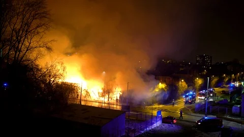 Fireman's trying to control fire in an industrial building during the night. Video stock 102644897