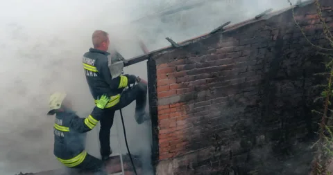 Firemen in action on burning ruins of building Stock Footage 167437376