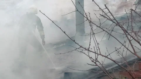 Firemen in action on burning ruins of building Stock Footage 237210775