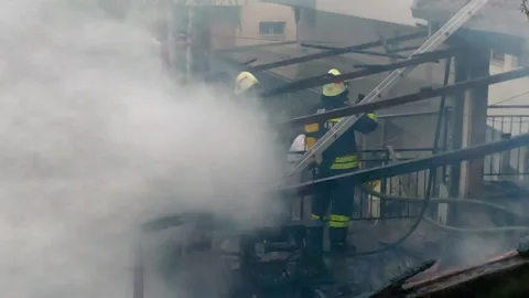 Firemen in action on burning ruins of building Stock Footage 237214849