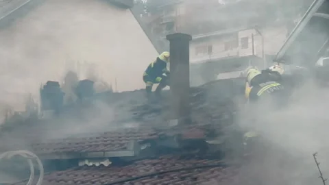 Firemen in action on burning ruins of building Stock Footage 237214916
