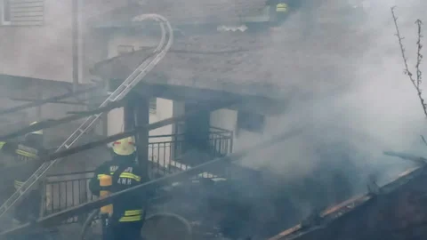 Firemen in action on burning ruins of building Stock Footage 237214956