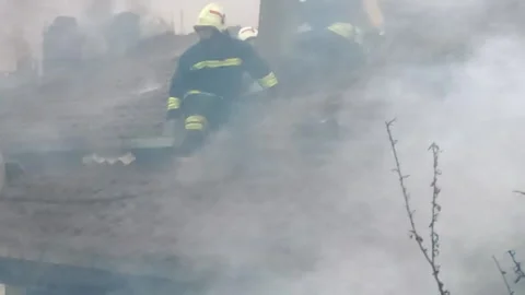 Firemen in action on burning ruins of building Stock Footage 237214979
