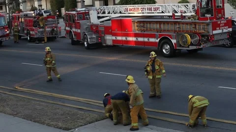 Firemen in action rolling up hoses Stock Footage 52046919