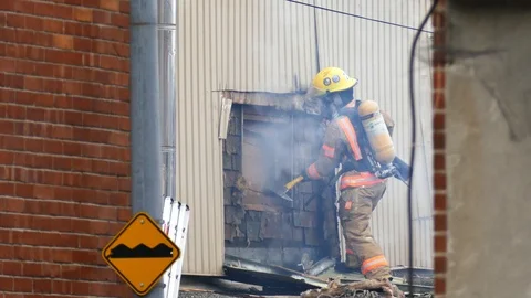 Firemen axing wall Stock Footage 120121585