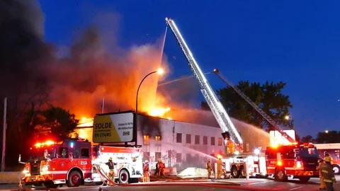 Firemen battling major blaze at night Stock Footage 115971071