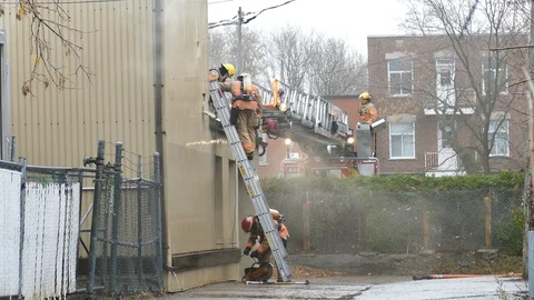 Firemen bringing chainsaw on roof Stock Footage 120120764