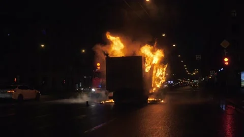 A firemen came to extinguish a large burning car in the middle of the road. Vidéo 155660357