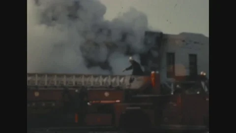 Firemen extinguishing the fire while crowd watching it - 1968 Stock Footage 83659022