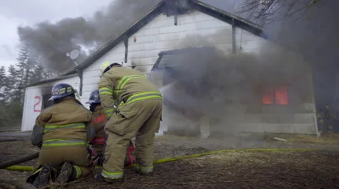 Firemen get ready to spray house Stock Footage 60957785