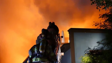 Firemen getting on roof burning in flames Stock Footage 116122646