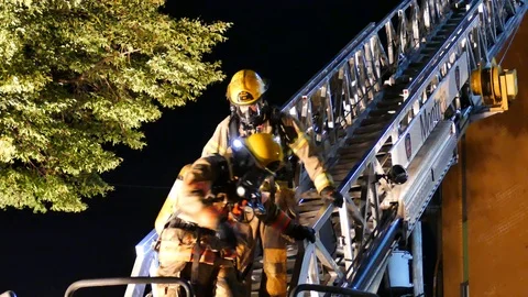 Firemen getting off truck ladder Stock Footage 116017331