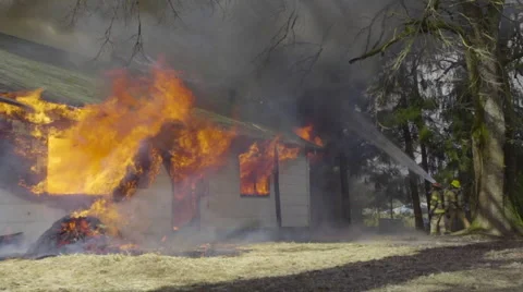 Firemen hose down burning house Stock Footage 60986043