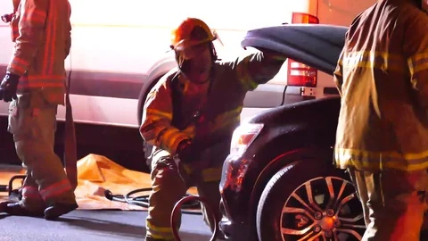 Firemen opening hood of a car crashed Stock Footage 100618827