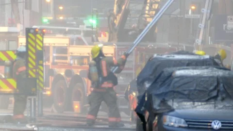 Firemen operating and rising heavy ladder with large metal poles Stock Footage 89414461