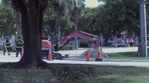 Firemen removing backhoe from gas main break 動画素材 27866531