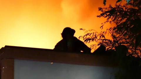Firemen on roof of structure fire Stock Footage 116076475