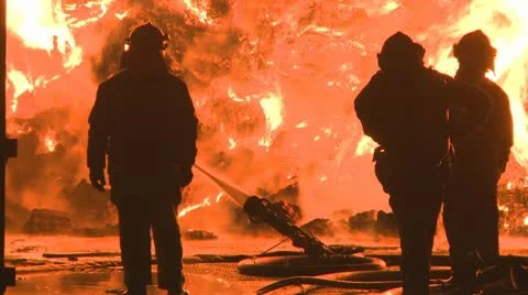 Firemen silhoueted at a large blaze Stock Footage 10686497