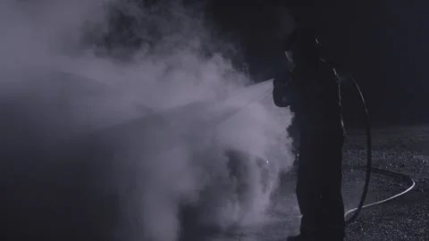 Firemen silhouette combating a fire on a burned car accident at night with water Stock-Footage 256037412