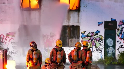 Firemen splashing flames Stock Footage 116012067