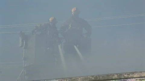Firemen spray from crane bucket Stock Footage