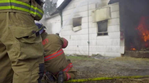 Firemen spray down house on fire Video stock 60959431