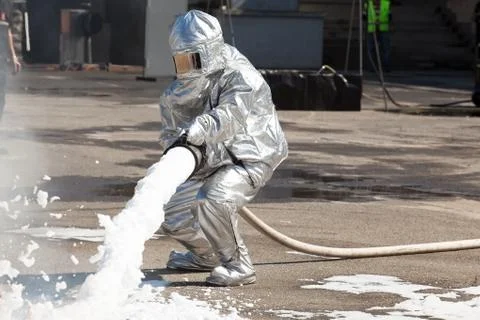 Firemen spray firefighting foam Foto stock