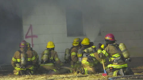 Firemen spray water through a widow Stock Footage 60958875
