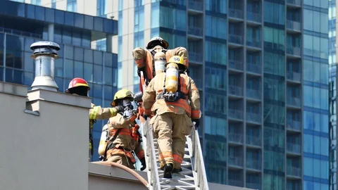 Firemen on top of condo building Stock Footage 116078025