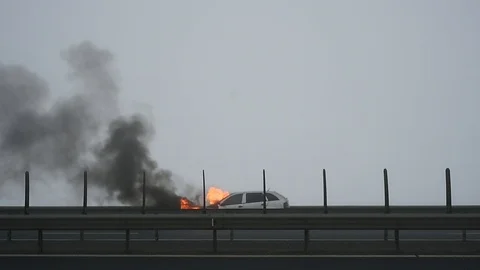 Firemen try to extinguish a burning car on a highway Stock-Footage 101550665