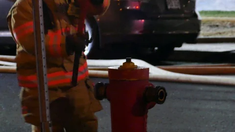 Firemen trying to plug hoses at fire hydrant Vidéo 114706890