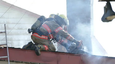 Firemen using power tools and water hose on building rooftop - Commercial Stock Footage 50008283