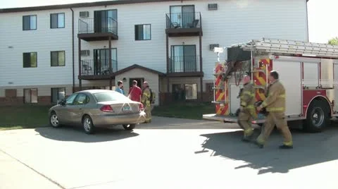 Firemen Walking &amp; Talking to Victims on Scene Stockbeeldmateriaal 12580194